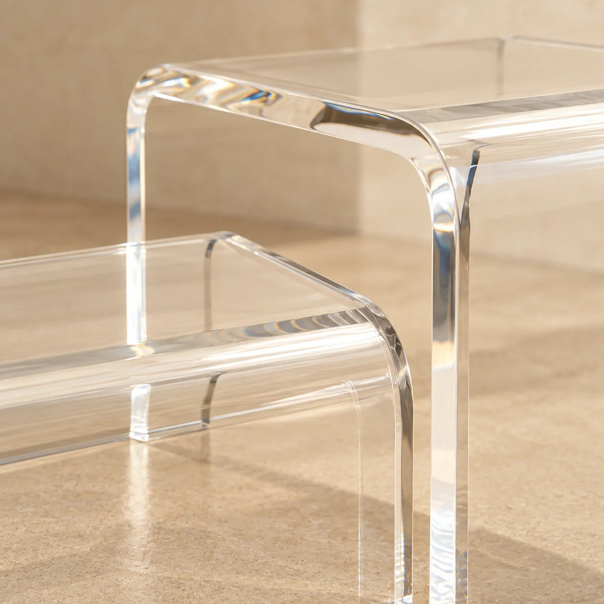 Escada modular Altea em acrílico cristal, em detalhe da borda curva e da junção.