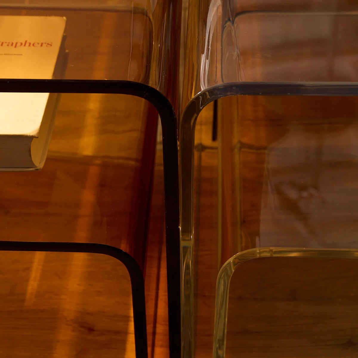 Mesa lateral Vértis em acrílico âmbar, em detalhe junto à versão transparente.