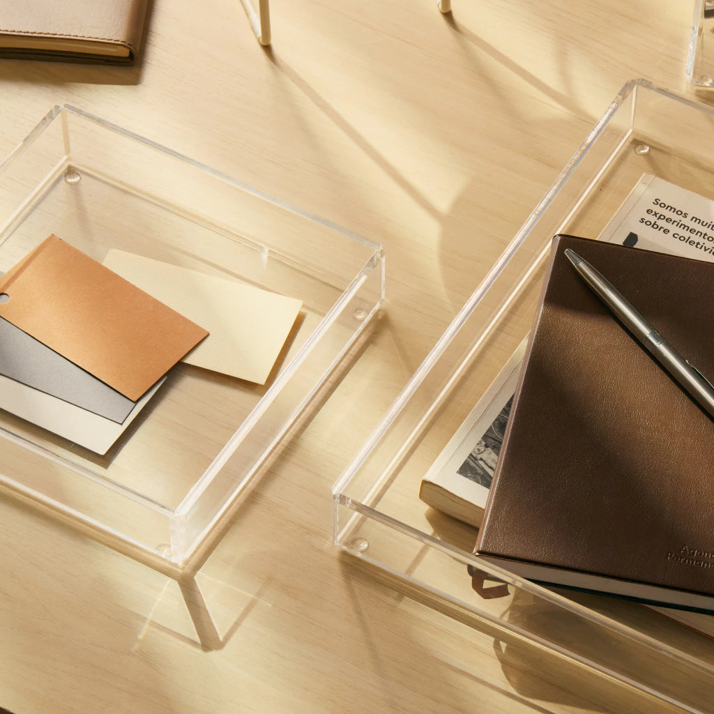 Caixa organizadora Velune em acrílico cristal, em composição com bandeja e materiais de escritório.