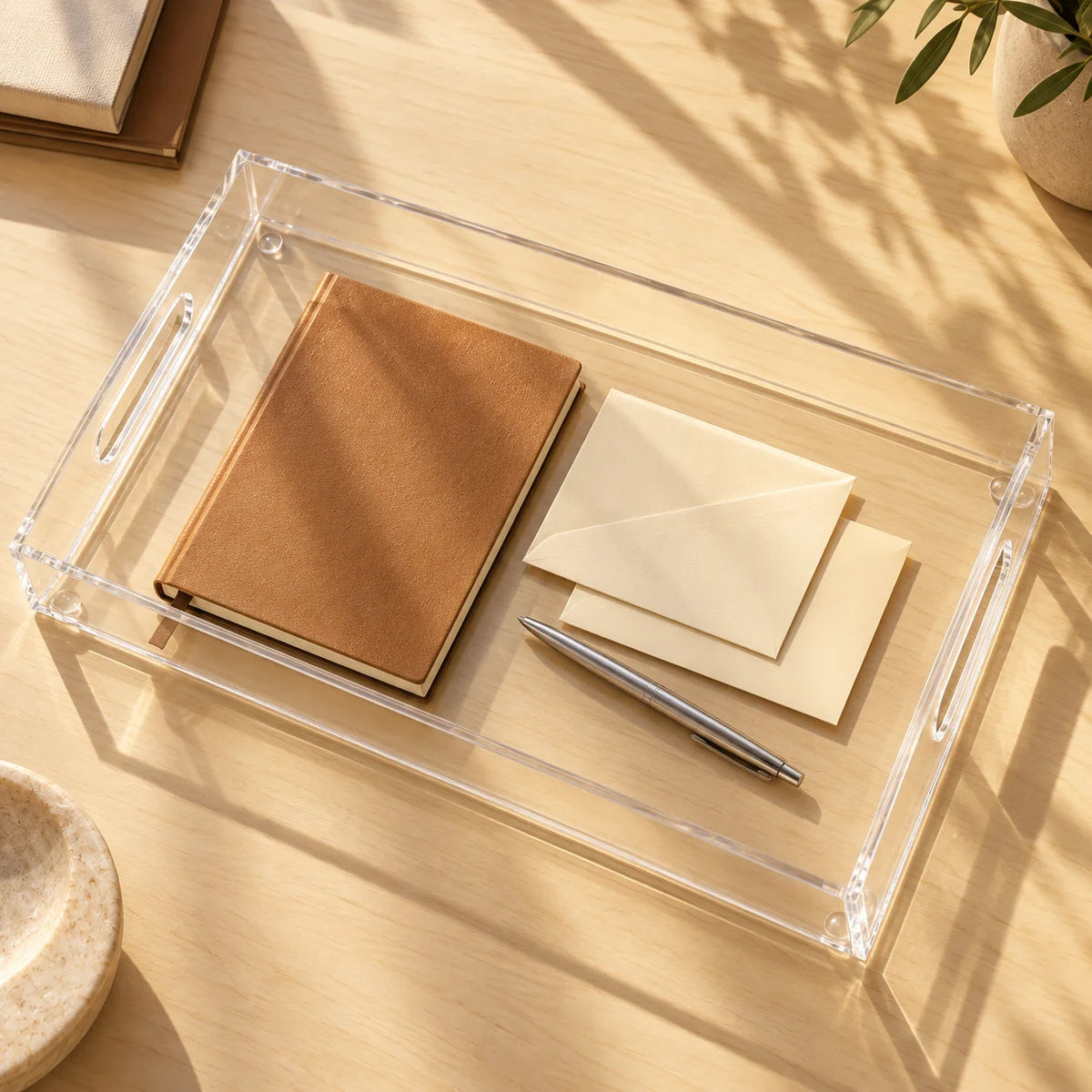 Bandeja Nítida em acrílico cristal, com caderno e papéis sobre mesa.