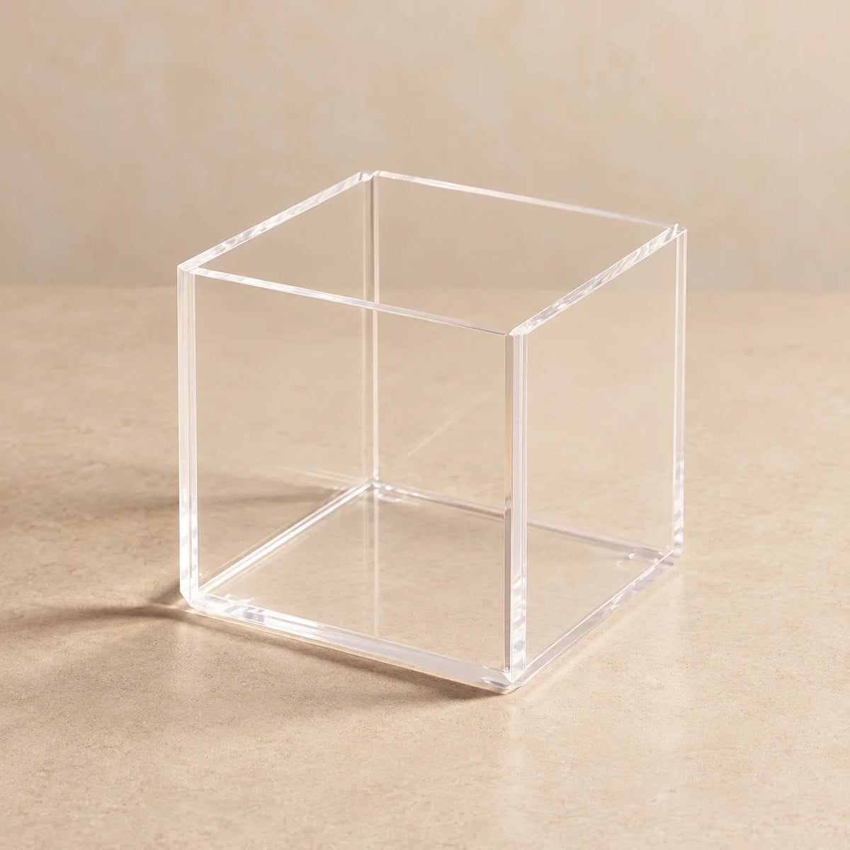 Cubo organizador Nivora em acrílico cristal, vazio sobre fundo neutro.