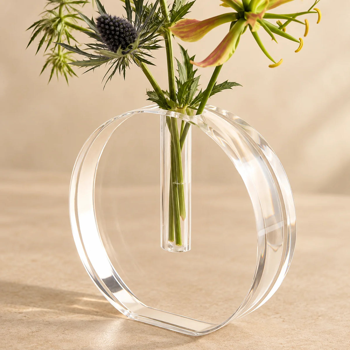 Vaso Sinué em acrílico cristal, em detalhe do corpo circular com flores.