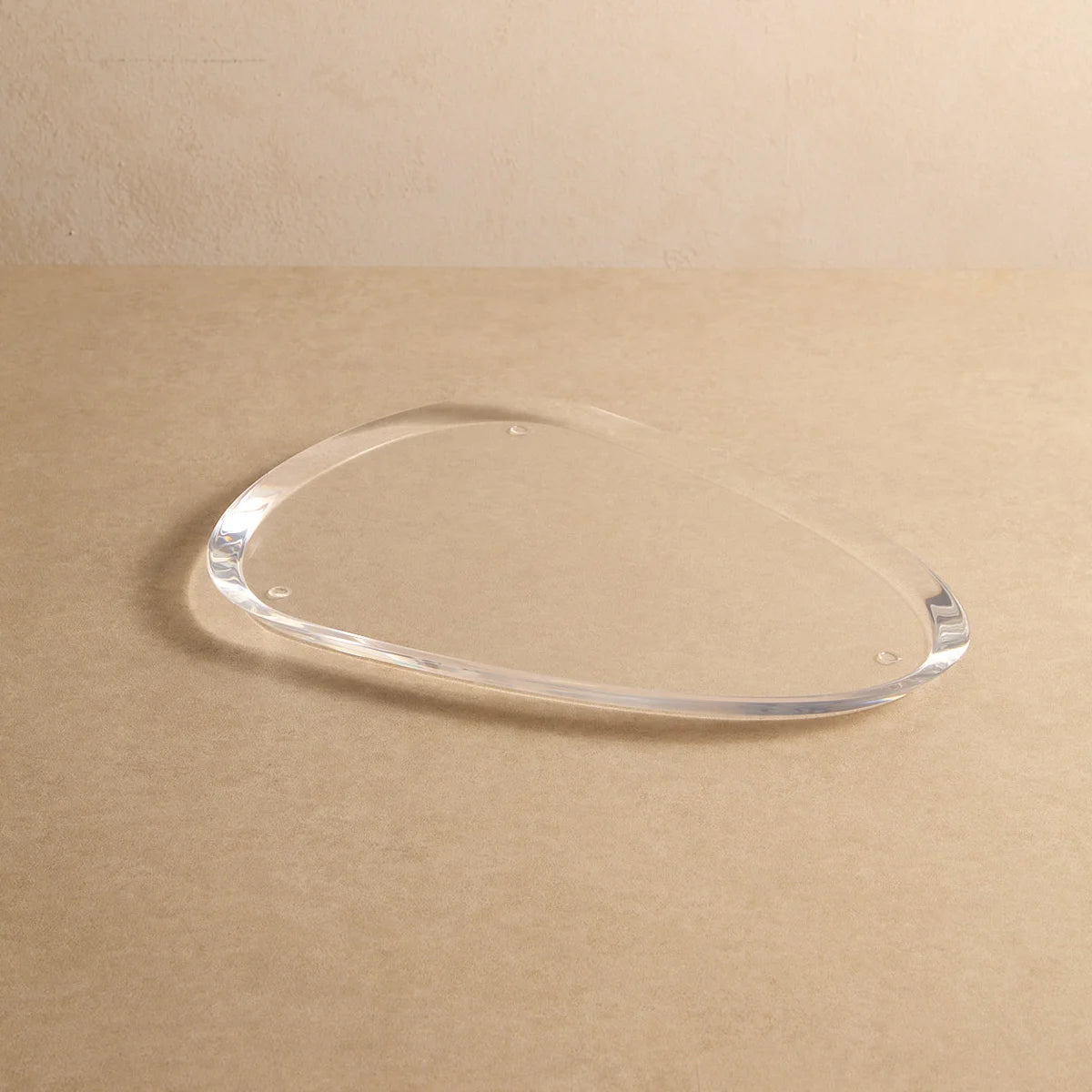 Base oval Elísea em acrílico cristal, vazia sobre fundo bege.
