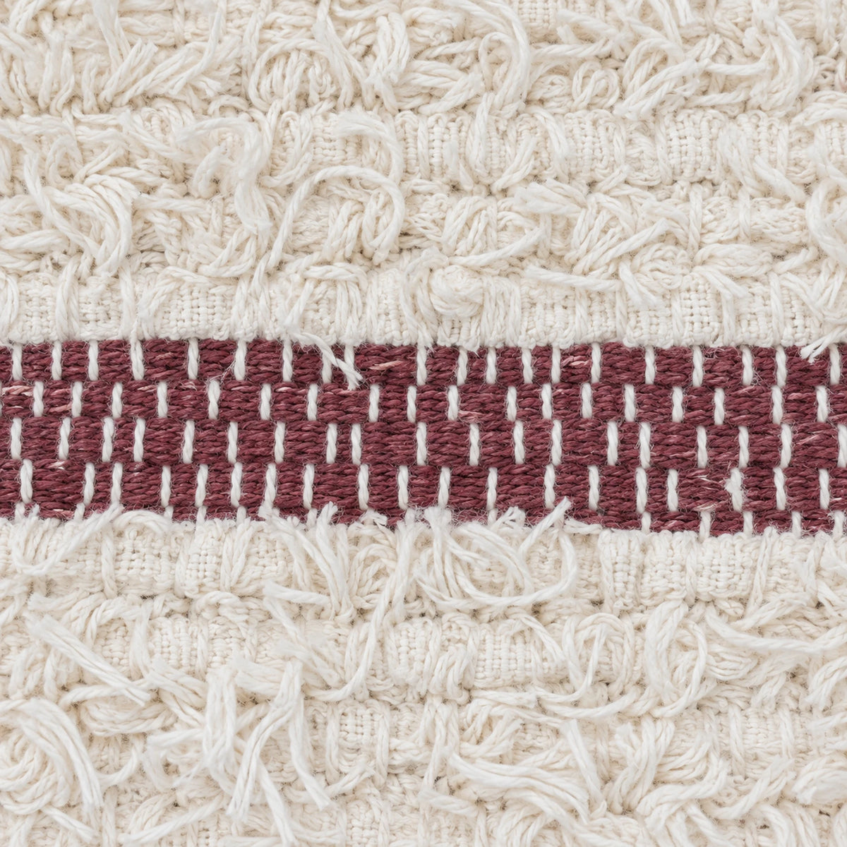 Detalhe da textura do algodão do tapete Aurora, com faixa marsala; imagem gerada por IA.