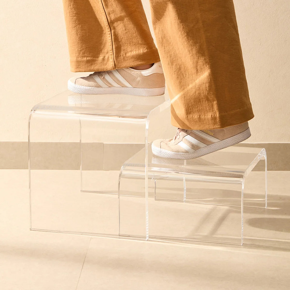 Escada modular Altea em acrílico cristal, com pessoa de sapatos sobre os degraus.