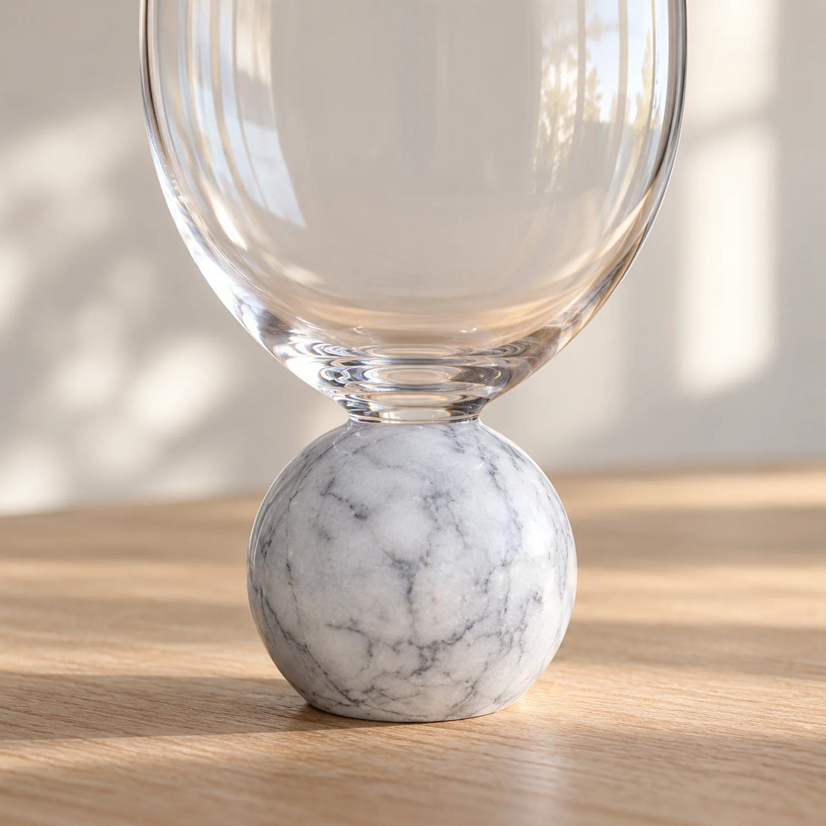 Detalhe da base esférica em mármore branco da taça Orvieto