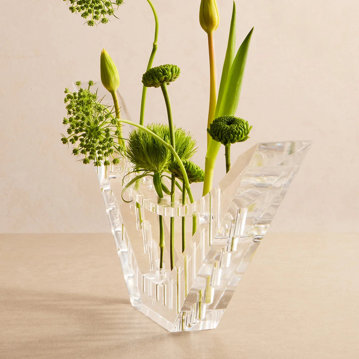 Vaso Ascenda em acrílico cristal, visto de lado com arranjo floral.
